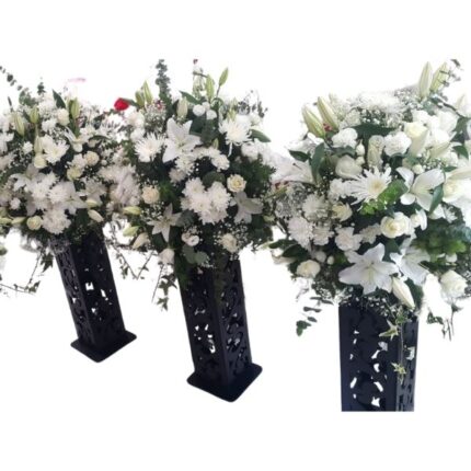 Classic Conference Bloom with white lilies, chrysanthemums, and baby’s breath in a sleek black floral stand for corporate events and conferences.