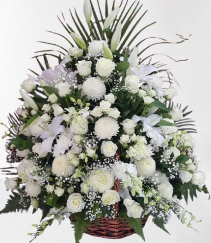 A beautiful basket arrangement featuring white lilies, roses, orchids, and baby’s breath, perfect for any elegant occasion.