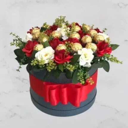 Roses & Chocolate Charm – Round box filled with red and white roses and Ferrero Rocher chocolates, finished with a red ribbon.